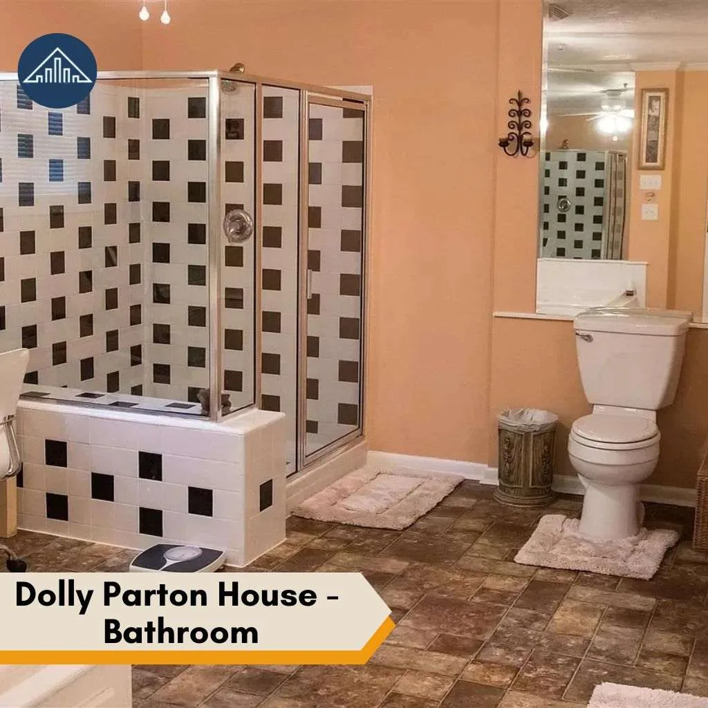 A classic bathroom with checkered shower tiles and a white toilet inside the Dolly Parton House.