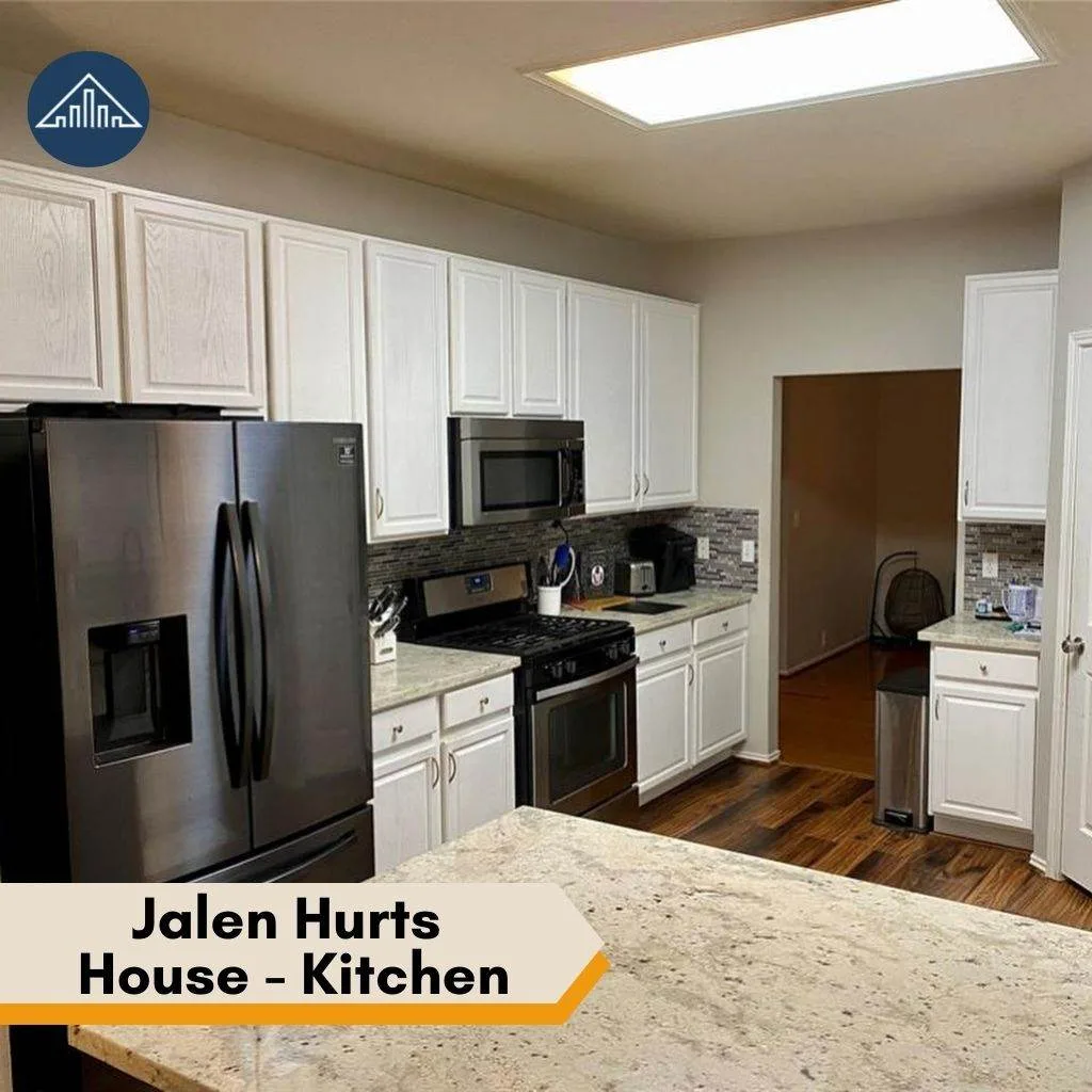 A modern kitchen with white cabinets and stainless appliances inside the stunning Jalen Hurts house.