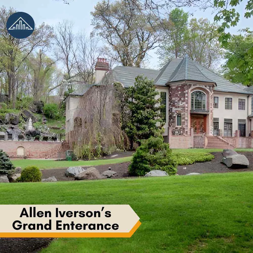 Exterior view of the Allen Iverson house showing the stone facade and a lush green lawn.